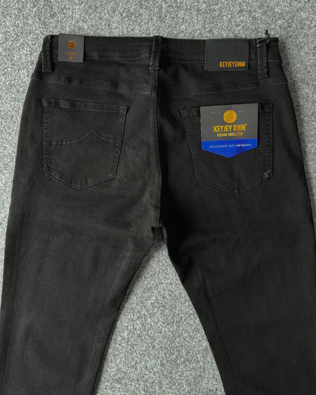 Dettaglio patch logata e logo metallizzato jeans slim fit nero - Archivio Tessile