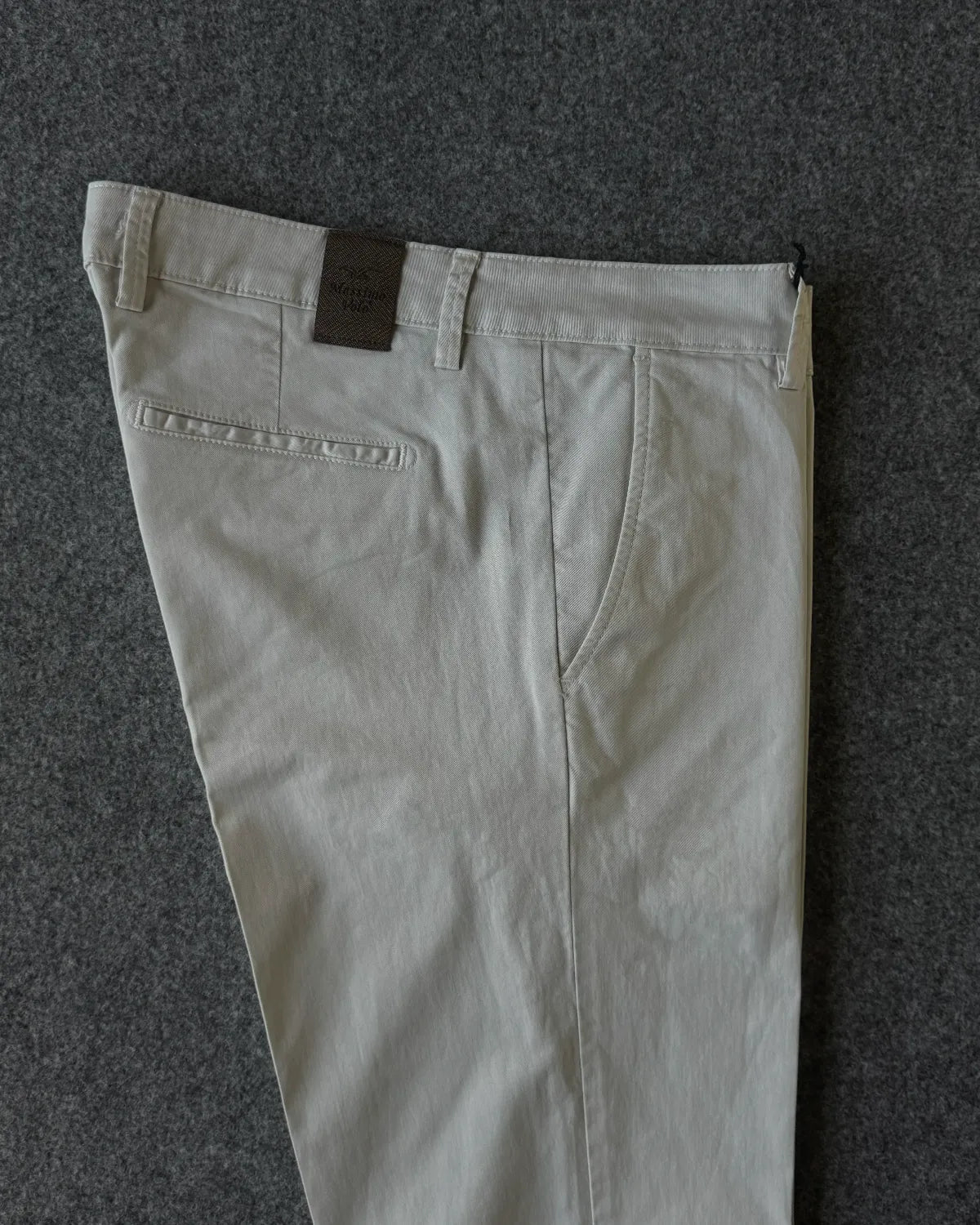 Dettagli patch logata e tasche pantalone in cotone gabardina avorio - Archivio Tessile