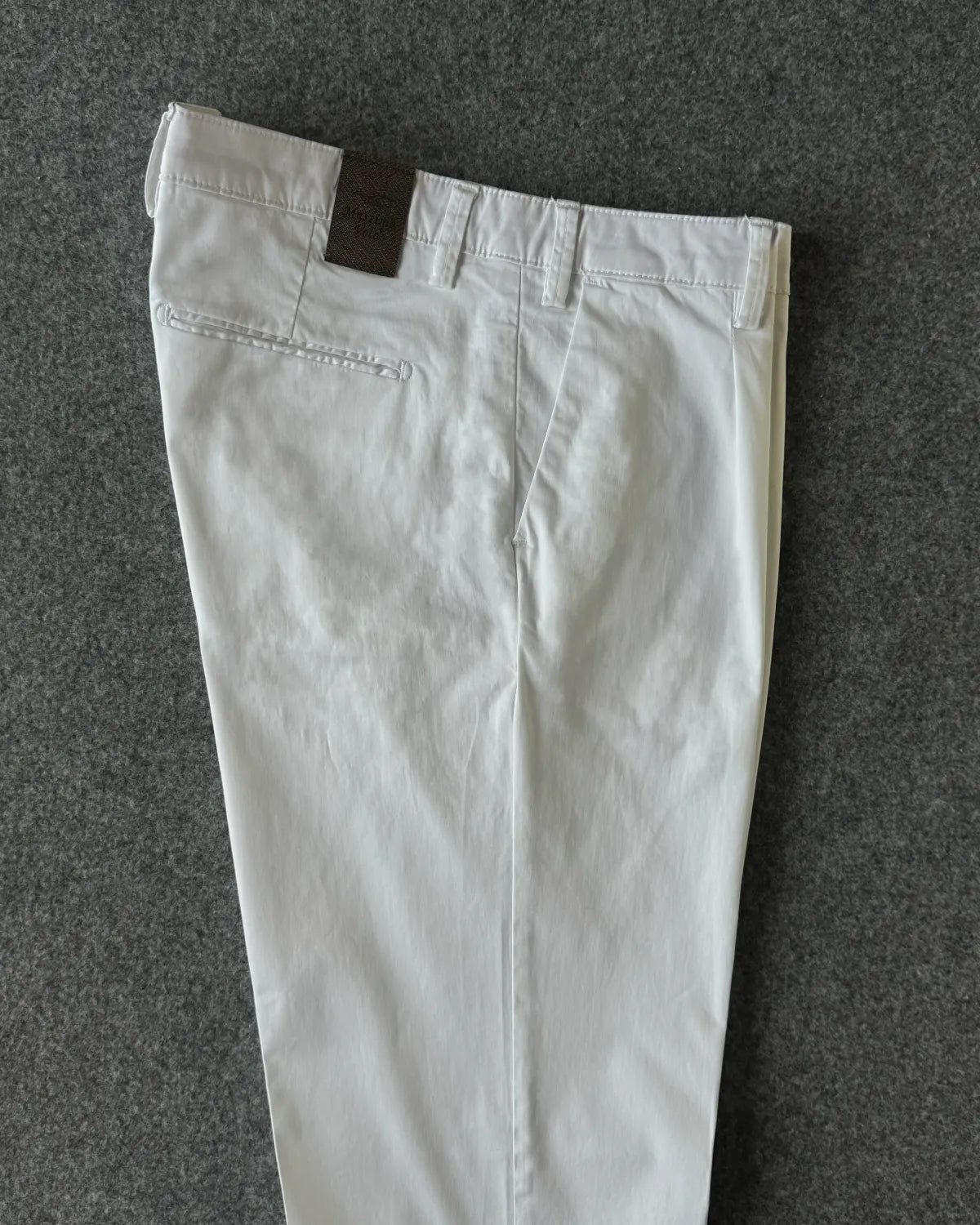 Dettagli patch logata e tasche pantalone in cotone rasato bianco - Archivio Tessile