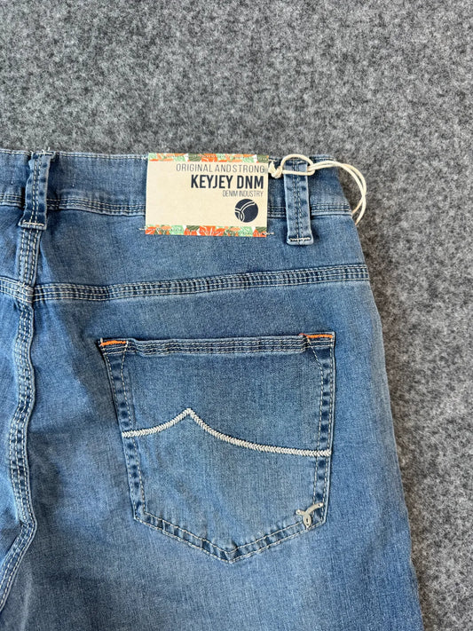 Dettaglio posteriore bermuda di jeans azzurro chiaro con patch logata - Archivio Tessile